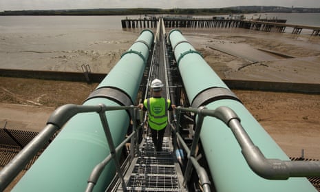 A worker walks between transfer pipes at the desalination plant in Beckton, east London