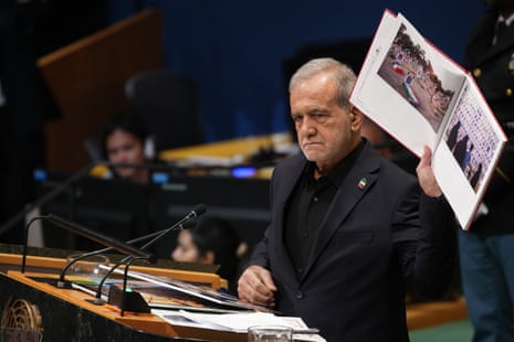 Ο Masoud Pezeshkian, συνοφρυωμένος βαθιά, κρατά μια εικόνα για να δείξει το πλήθος που συγκεντρώθηκε στα Ηνωμένα Έθνη