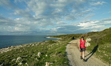 Female hiker walking on a rural road at Cape Agios Aikaterini, near Agios Spiridon on the island of Corfu, Greece