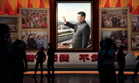 People stand in front of images of Chinese President Xi Jinping at the Museum of the Communist party of China in Beijing on 4 September 2022.