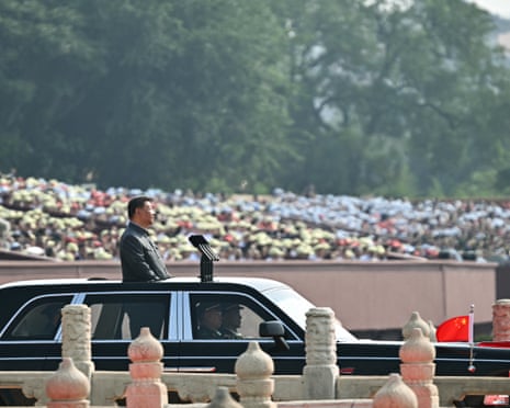 China's President Xi Jinping inspects the troops in open-topped car.