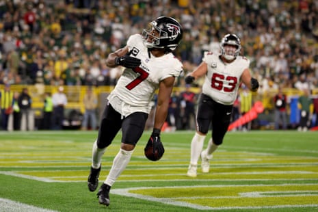 Bijan Robinson celebrates with Atlanta Falcons teammate Chris Lindstrom after scoring a fourth-quarter touchdown against the Green Bay Packers at Lambeau Field.