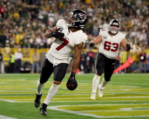 Bijan Robinson celebrates with Atlanta Falcons teammate Chris Lindstrom after scoring a fourth-quarter touchdown against the Green Bay Packers at Lambeau Field.