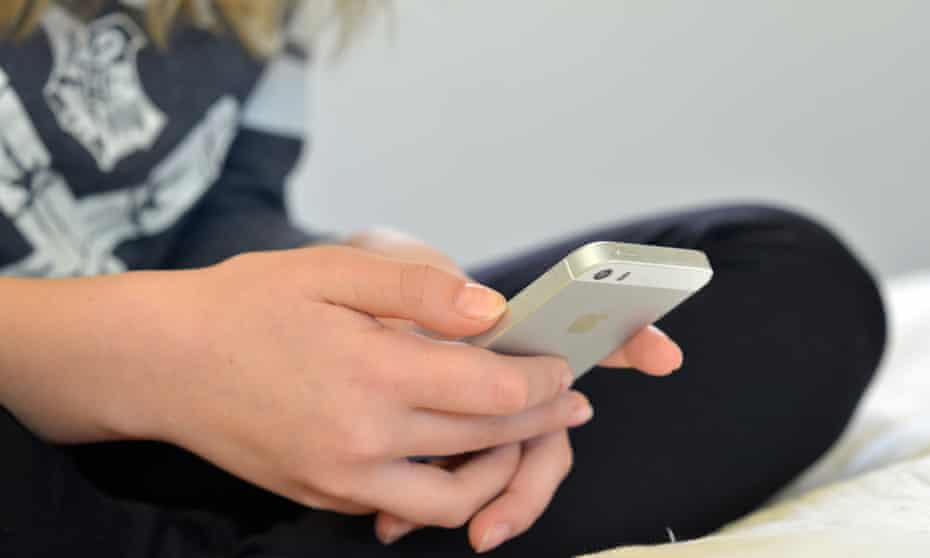 A teenager holding a mobile phone