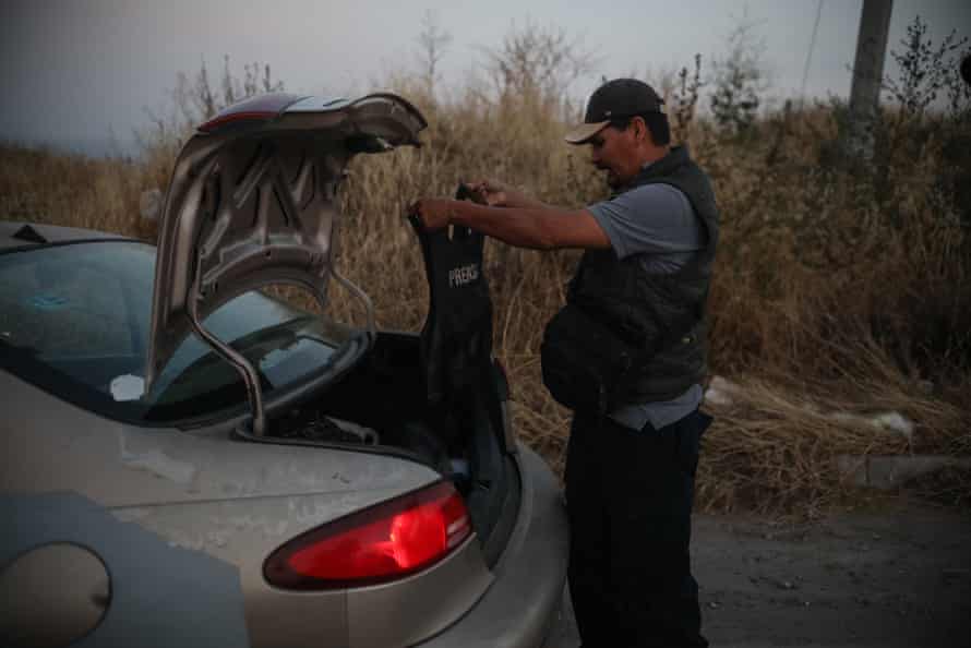 Margarito Martínez Esquivel removes a flak jacket from the boot of his car