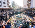 People gather around a makeshift memorial to pay their respects by laying flowers, candles and messages near the Constellation bar, in Crans-Montana in honour of the victims of the fire that ripped through the venue in the luxury Alpine ski resort on New Year's Eve.