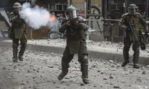 Police shoot tear gas and a shotgun during clashes with anti-government protesters in Santiago, Chile, in November. A UN team has called for the immediate end to the indiscriminate use of anti-riot shotguns.