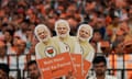 A supporter of India's ruling Bharatiya Janata party holds cutouts of Narendra Modi in Bengaluru, Karnataka