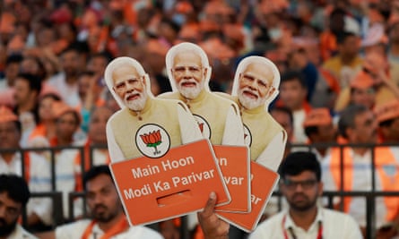 A BJP supporter holds cutouts of prime minister Narendra Modi during an election campaign event in Bengaluru, Karnataka this month.