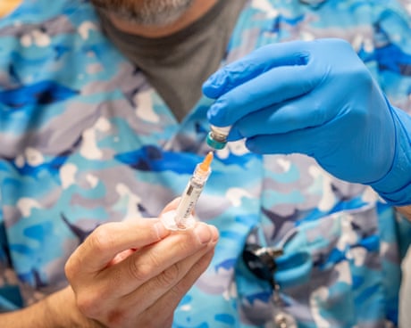 close up of a pair of hands filling a syringe