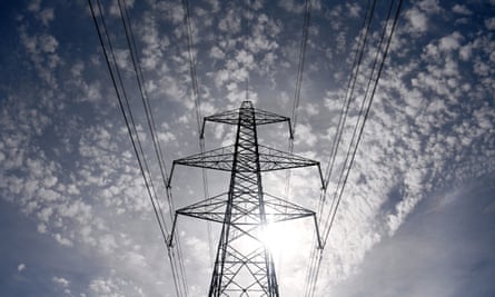 The sun rises behind an electricity pylon at Little Cheyne Court in Romney