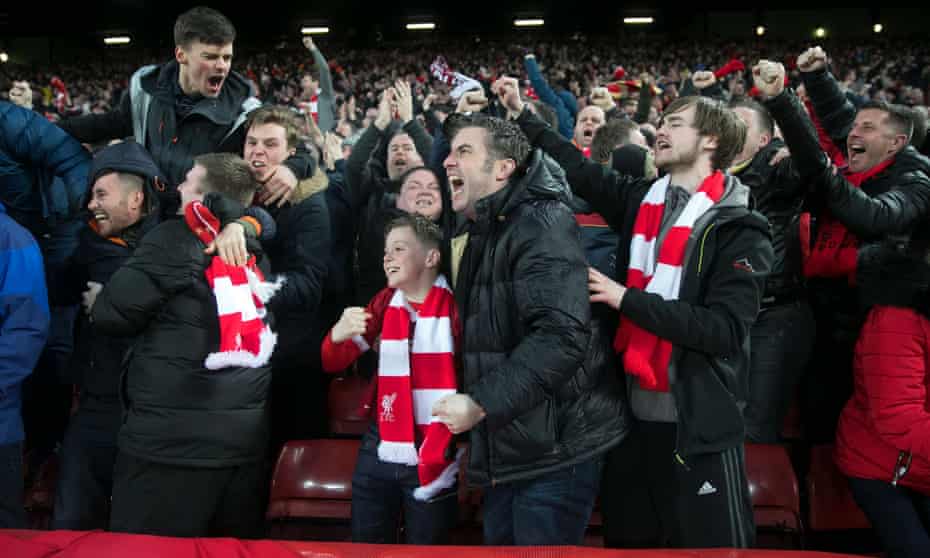 Liverpool fans in the Kop celebrate the first goal.