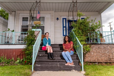 Two women sit on a house stoop