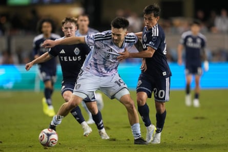 San Jose Earthquakes forward Preston Judd, middle, brings the ball up the field against Vancouver Whitecaps midfielder Andrés Cubas