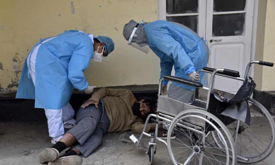 Health workers prepare to help a patient allegedly infected with the new coronavirus, who was found in the yard, get on a wheelchair, in the Clinics hospital in La Paz last week.