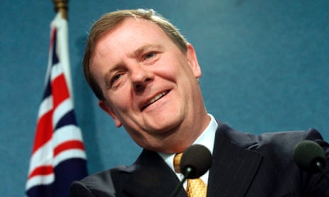 Former Australian treasurer Peter Costello standing in front of an Australian flag