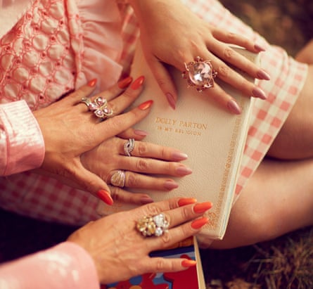 The hands of Dolly Parton fans Alice Hawkins and Trixie Malicious on top of a book about the singer, London, 2019