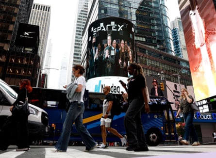 People walk by a SpaceX billboard in Times Square