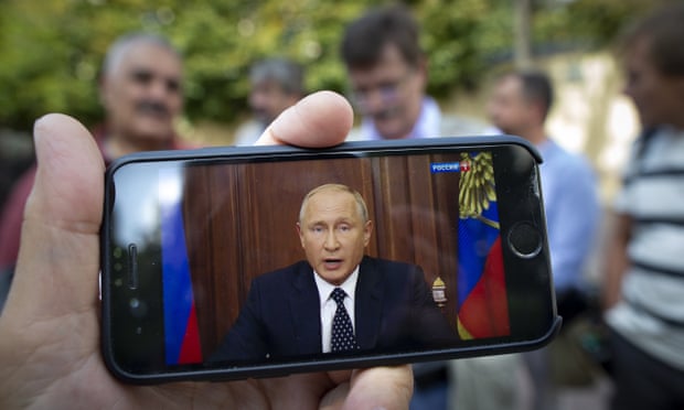 Vladimir Putin speaking on TV, shown on a smartphone