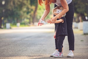 A women cleans a child's hands with a wipe