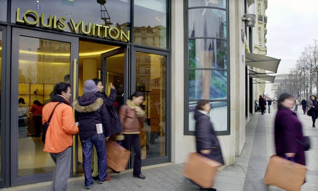 Shoppers leave the Champs Elysees Louis Vuitton shop in Paris