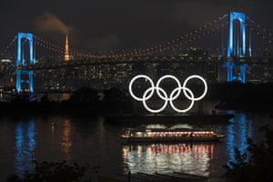 Illuminated Olympic rings are seen in front of Tokyo Tower to mark one year until the Tokyo Olympic Games.