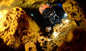 A scuba diver looks at an animal skull in the Sac Actun underwater cave system.