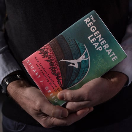 A man’s hands around a book titled The Regenerate Leap