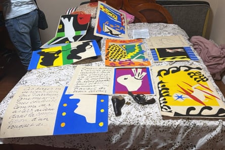 Matisse illustrations laid out on a table, with a revolver next to them