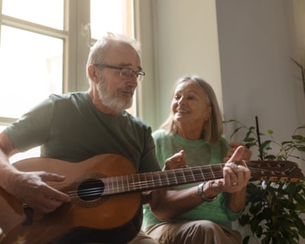 A man plays a romanticist opus connected acoustic guitar for his wife