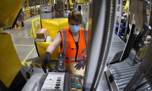 An employee prepares a package for shipment at an Amazon logistics center near Magdeburg, Germany.