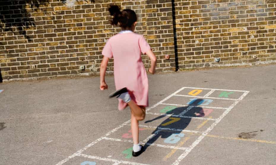 Young girl playing hopscotch in school playground