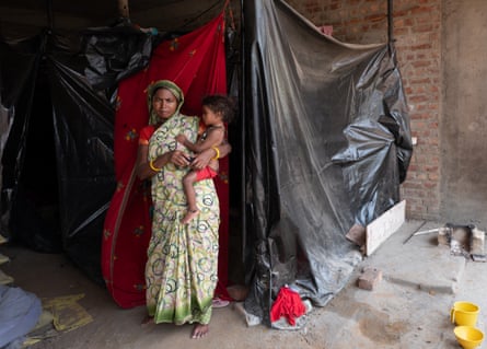 Kumkumari and her two-year-old daughter stand outside their makeshift tent at a construction site in Gurguram.