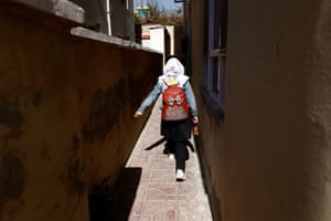 Hadia, 10, a 4th grade primary school student, walks back from school through an alleyway near her home in Kabul