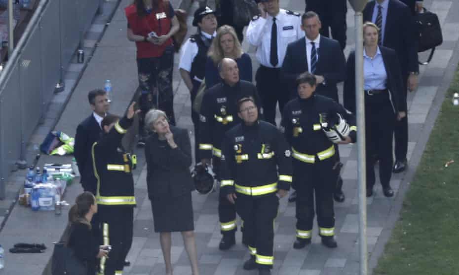 Theresa May meets with the emergency services outside Grenfell Tower.
