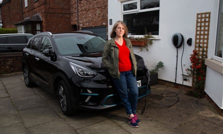 Lisa Johnson charging her electric car on the driveway of her home in Wilmslow, Cheshire.