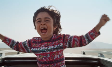 Child pops out of car sunroof in a still from Hit the Road