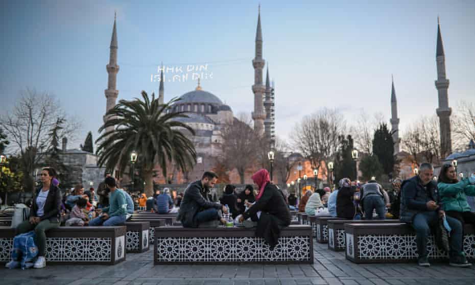 People eat iftar dinner on the first day of Ramadan in Sultanahmet Square, Istanbul.