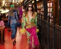 A model in a vibrant dress and dark sunglasses walks the Valentino catwalk in a library. Photo: Abdul Saboor/Reuters