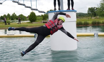 Liberal Democrats leader Sir Ed Davey in wetsuit and helmet falls from a floating assault course into the water during a campaign trail visit to Warwickshire