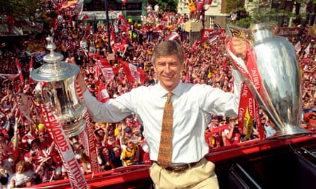 Wenger poses with the FA and League Cups in 1998, the first year that Arsenal did the double under Wenger.