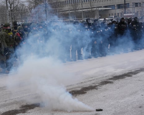 Immigration enforcement officers stand outside Bishop Henry Whipple Federal Building as teargas is deployed, 15 15 January 2026.