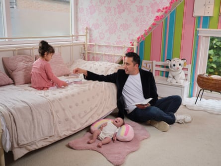 Enrique sits on the floor and plays with little pots on the bed with his youngest daughter, Alaia Belen.