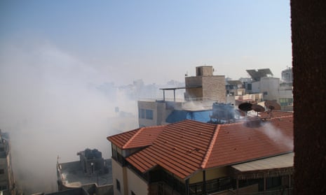 A cloud of white smoke hangs over rooftops in Gaza