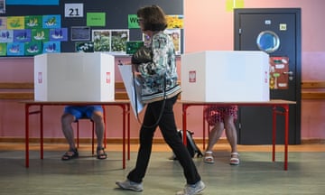 People cast their votes at a polling station during the European parliamentary elections in Warsaw, Poland. 