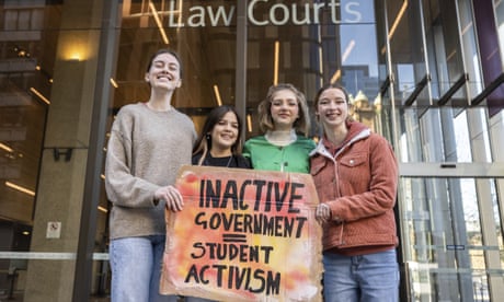 Youth climate activists Laura Kirwin, Izzy Raj-Seppings, Ava Princi and Liv Heaton pose for a photo outside The Federal Court of Australia in Sydney. They are holding a sign that says "Inactive Government = Student Activism"