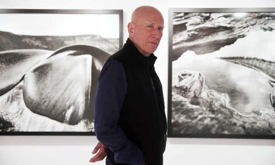 Brazilian photographer Sebastião Salgado with images from his Genesis exhibition at a gallery in Hong Kong, December 2013.