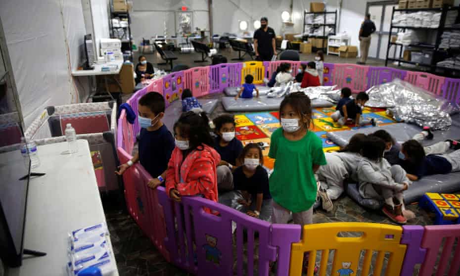 Unaccompanied migrants from ages three to nine watch TV inside a playpen at the facility in Donna, Texas, on 30 March. 