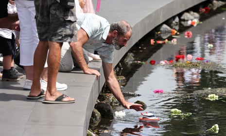 A family member of one of the Christchurch earthquake victims releases a toy boat into the Avon River during the national memorial service marking the 10th anniversary of the quake