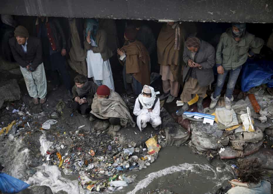 People shelter under the Pul-e Sokhta bridge in western Kabul, during a police round up of suspected drug addicts.